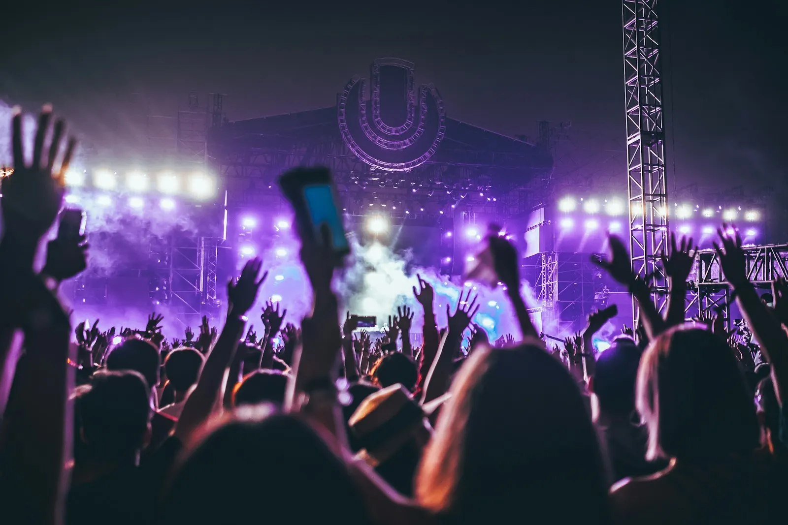 Mor ışıklı konser sahnesi ve seyirciler
