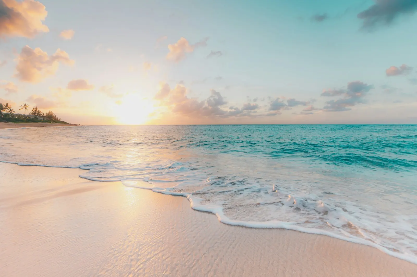 Waves on a sandy beach at sunrise