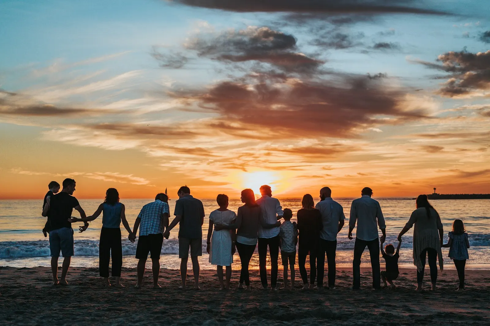 Group of people beside the sea at sunset