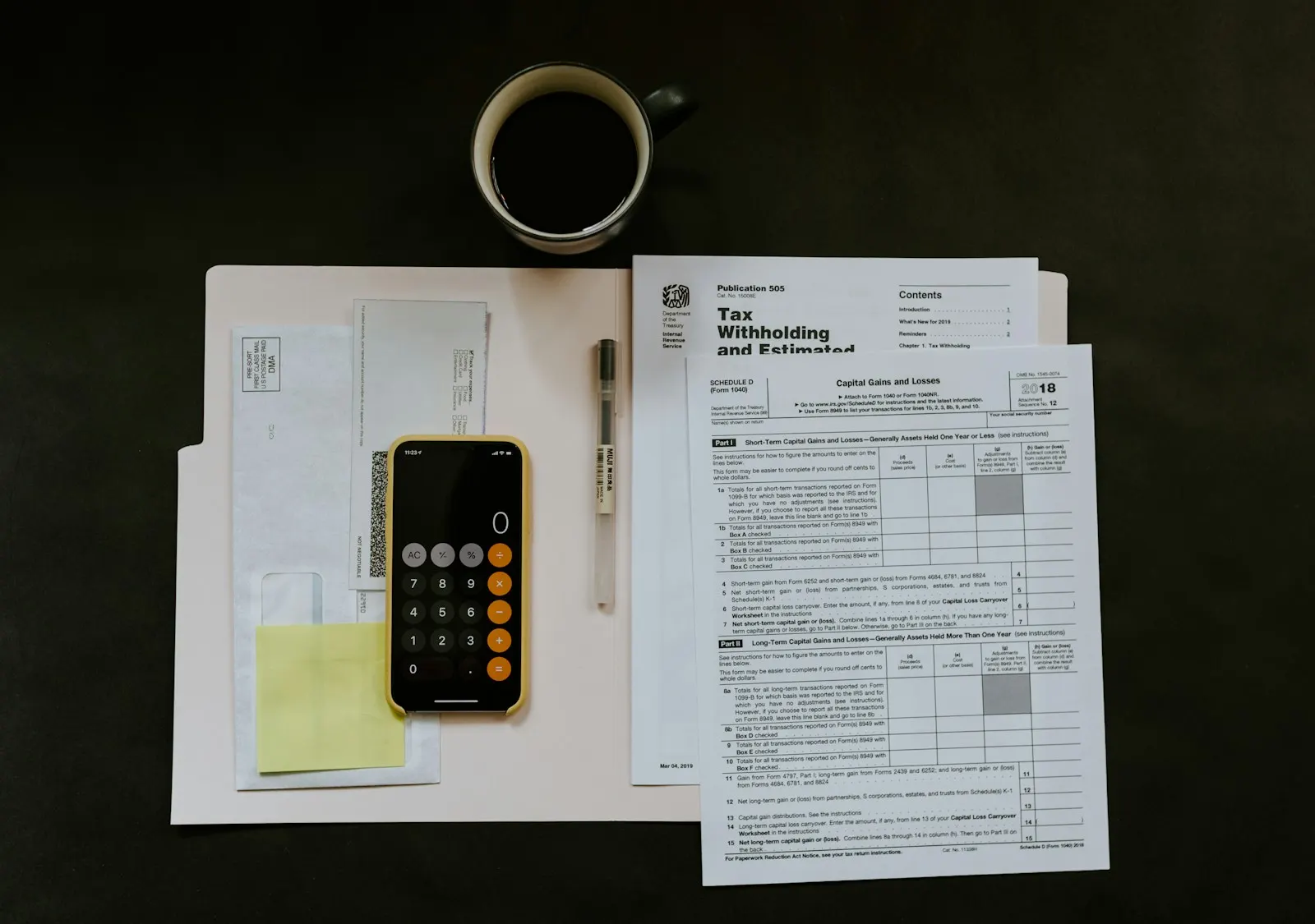 Documents financiers près d’une calculatrice et d’une tasse