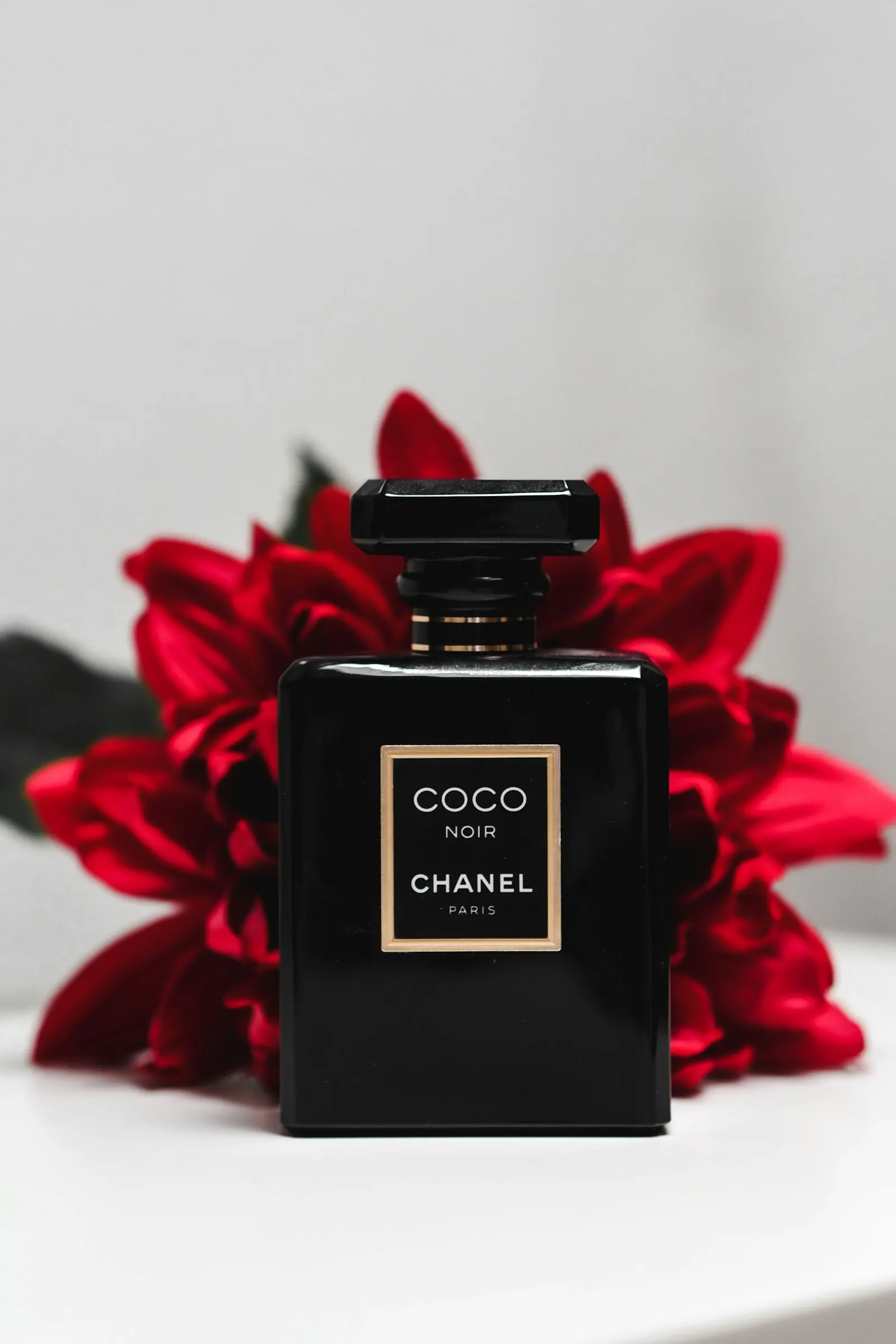 Perfume bottle framed by red roses