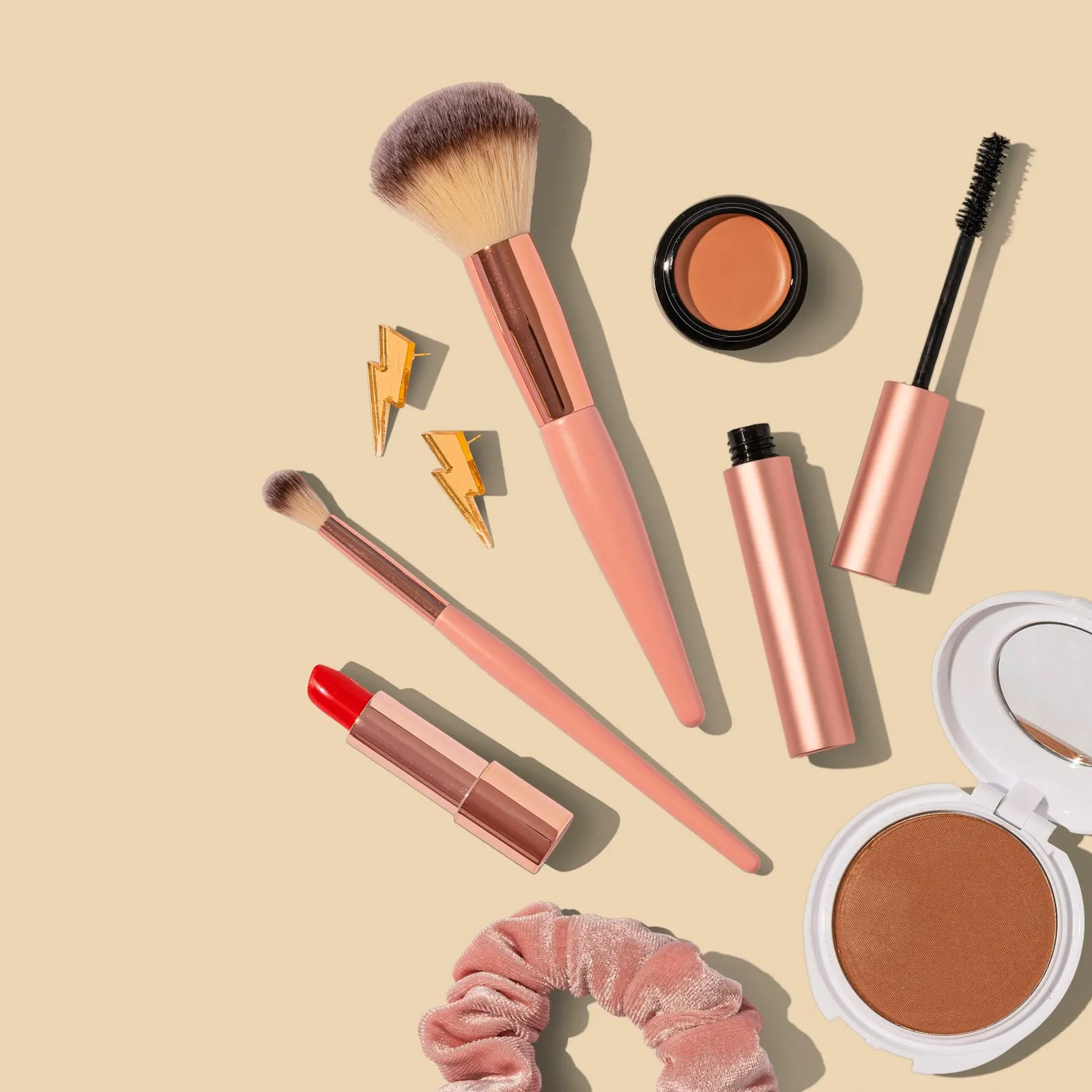 Cosmetics and brushes on a pale background